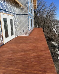 Aluminum Decking showcasing a wooden floor deck with a house in the background.