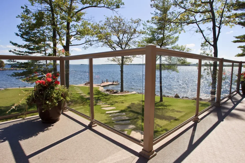 Topless Glass Railing provides a clear view of the water and trees in the background, enhancing the outdoor experience.