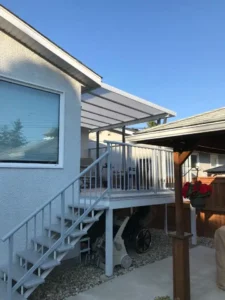 Acrylic Patio Covers product showcasing a patio with an awning and stairs that lead to a house.