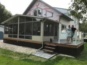 A couple stands on the porch of a house, showcasing the Insulated Glass Model 400 in a residential setting.
