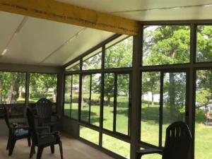 Insulated Glass Model 400 showing a screened-in porch with chairs and a table, inviting for relaxation.