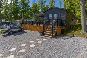 A quaint cabin with a golf cart parked outside, illustrating the RV/Resort Living experience and leisure activities.