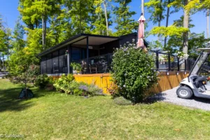 A golf cart parked in front of a house, showcasing RV/Resort Living lifestyle and outdoor leisure.