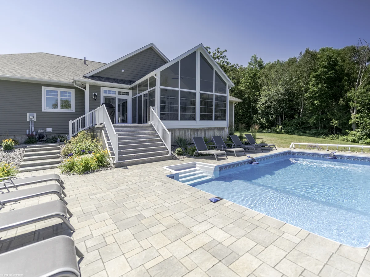 Patio and pool area featuring chairs, a deck, and enclosed porch walls for added privacy.