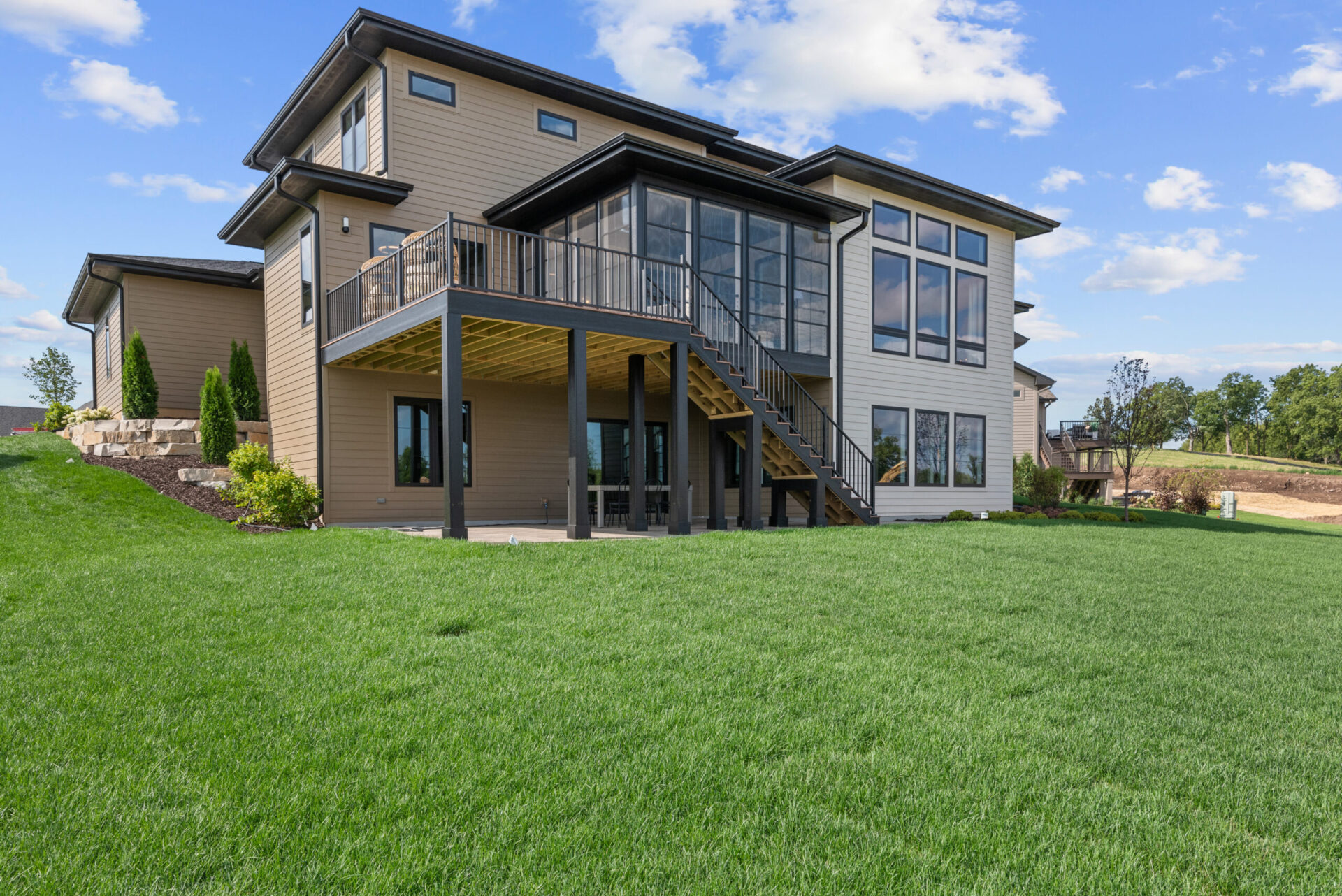 Modern home featuring a spacious lawn and deck, showcasing Screen Porches' design and outdoor living solutions.
