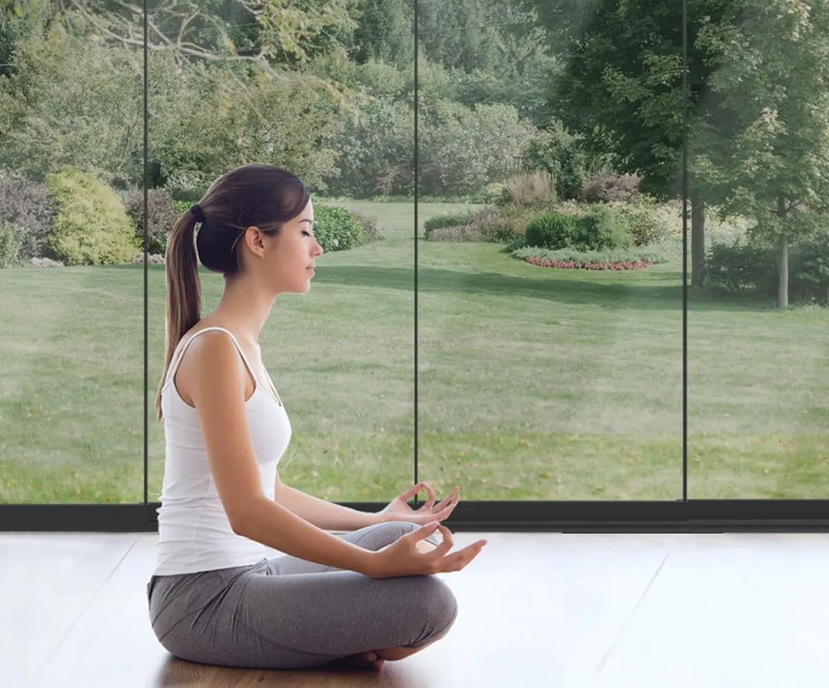 Woman practicing yoga with a peaceful outdoor backdrop, highlighting the Novasun Horizon.