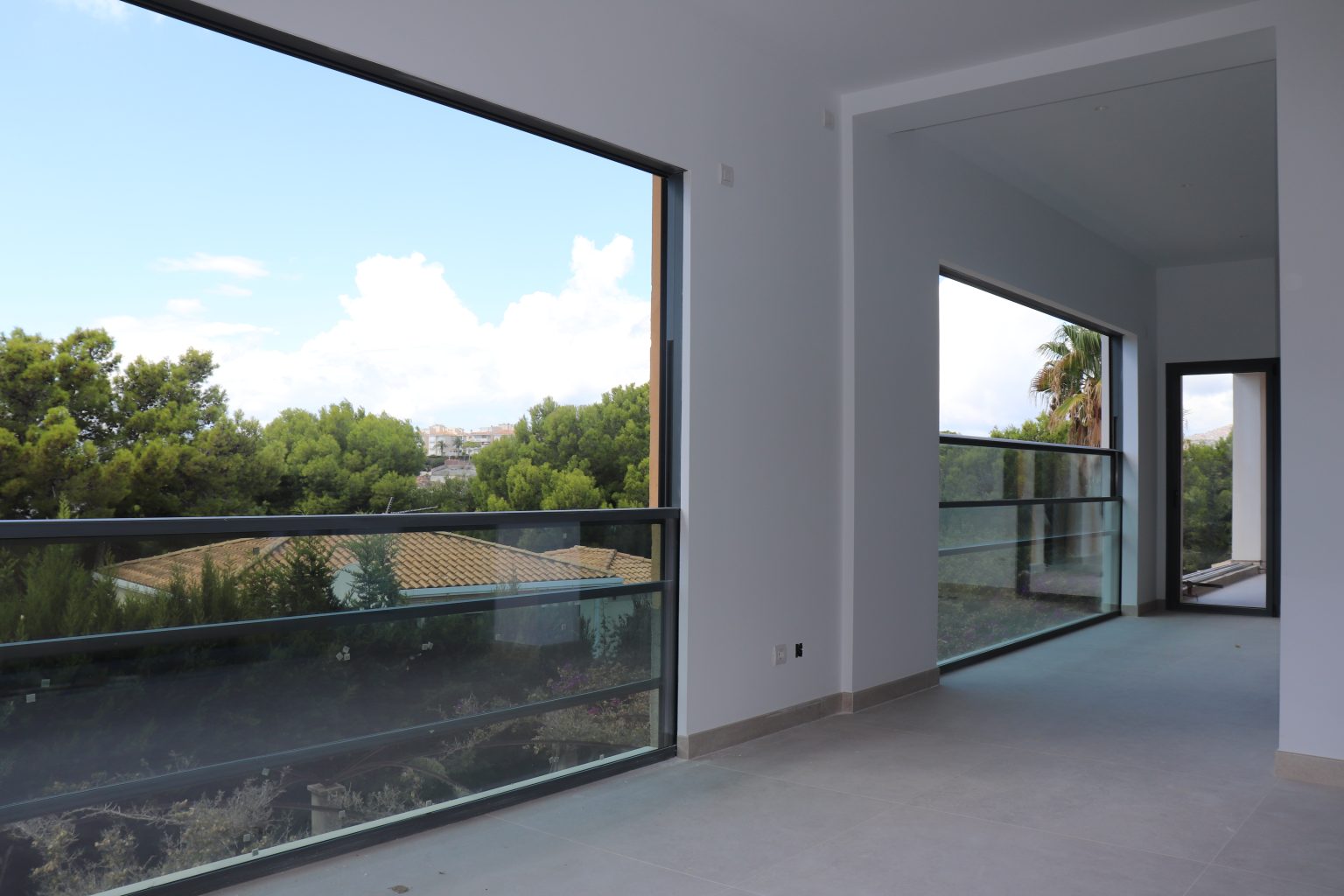 A spacious room with a large window and balcony, letting natural light brighten the space.