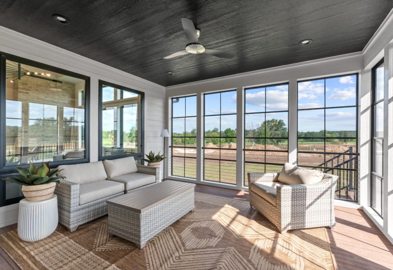 Cozy sunroom adorned with wicker furniture and numerous windows, perfect for enjoying sunlight and views.