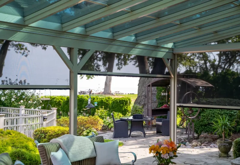 A covered patio with a table and chairs, highlighting a Retractable Screen System that adds comfort and privacy.