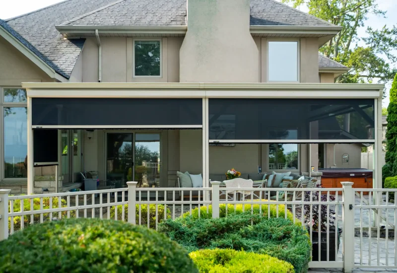 A patio with a retractable awning and fencing, highlighting a versatile and functional outdoor living space.