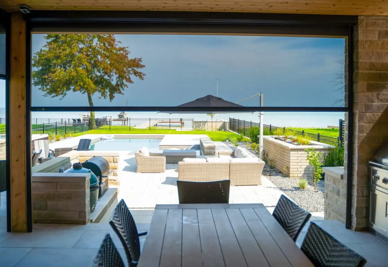 Outdoor patio with a grill and furniture, featuring a retractable screen system that enhances outdoor living.