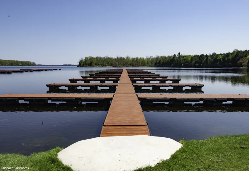 Elegant cedar-finish Aluminum Decking with a frameless glass railing, providing clear, unobstructed views of the surrounding forest.