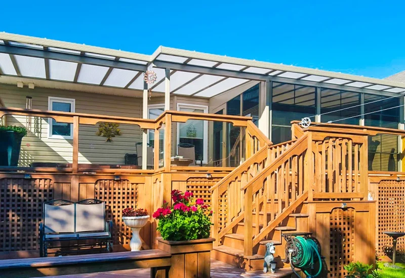 A wooden deck with a railing and stairs, representing the Hybrid Patio Covers design.