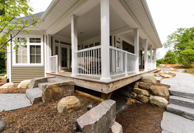 Aluminum Picket Railing on a porch with a stone walkway and a rock wall in the background.