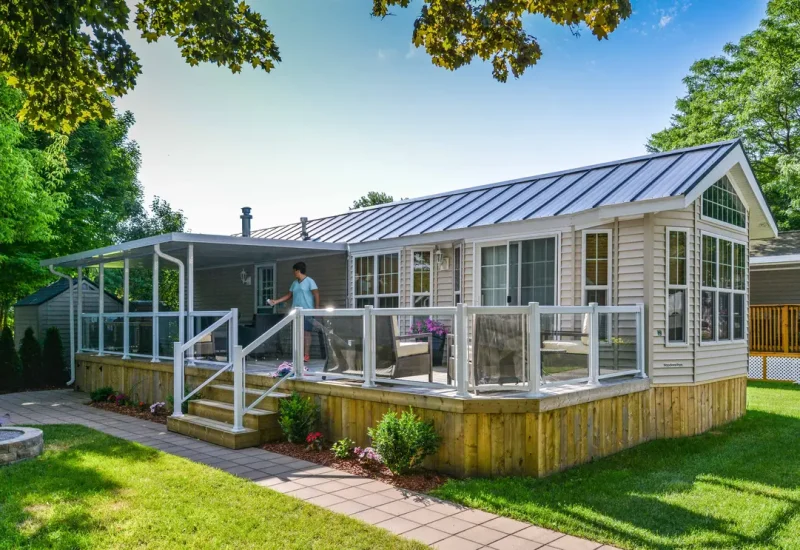 Small house featuring a porch and deck, showcasing aluminum railing with glass for a modern look.