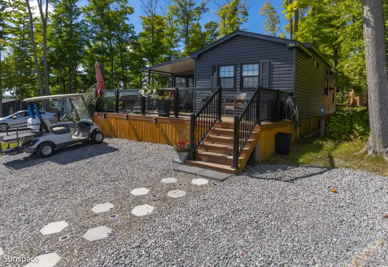 A quaint cabin with a golf cart parked outside, illustrating the RV/Resort Living experience and leisure activities.