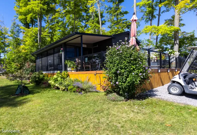 A golf cart parked in front of a house, showcasing RV/Resort Living lifestyle and outdoor leisure.