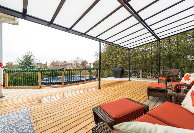 Sturdy Acrylic Patio Cover offering shade and weather protection, creating a comfortable outdoor living area with seating and garden views.