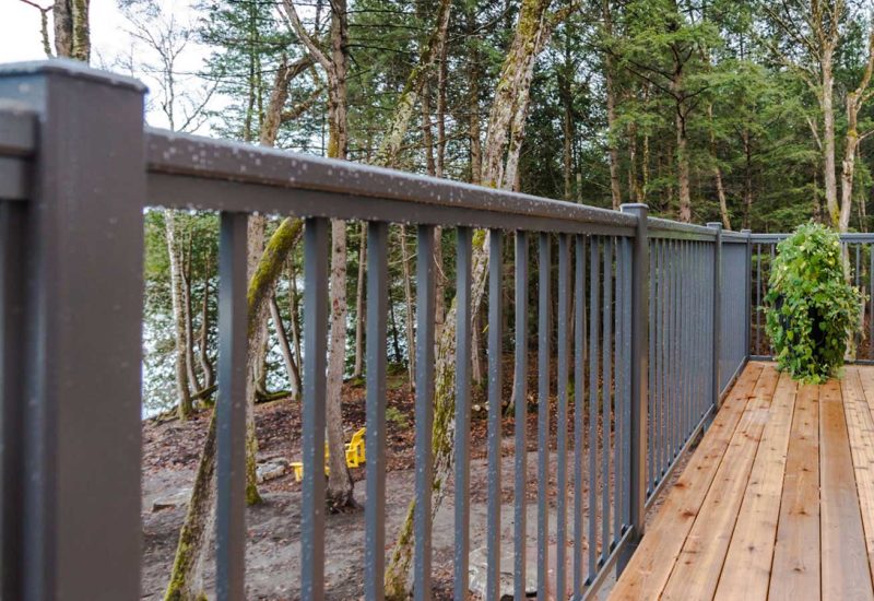 Aluminum Picket Railing on a deck, set against a tranquil lake backdrop.