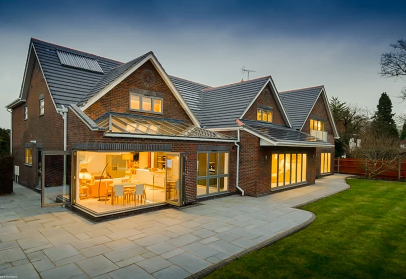 A spacious home with a large patio, showcasing a WeatherMaster™ Plus Bi-Fold Door system for effortless indoor-outdoor living.